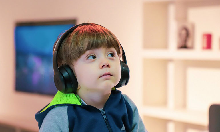 Young child with disability wearing headphones