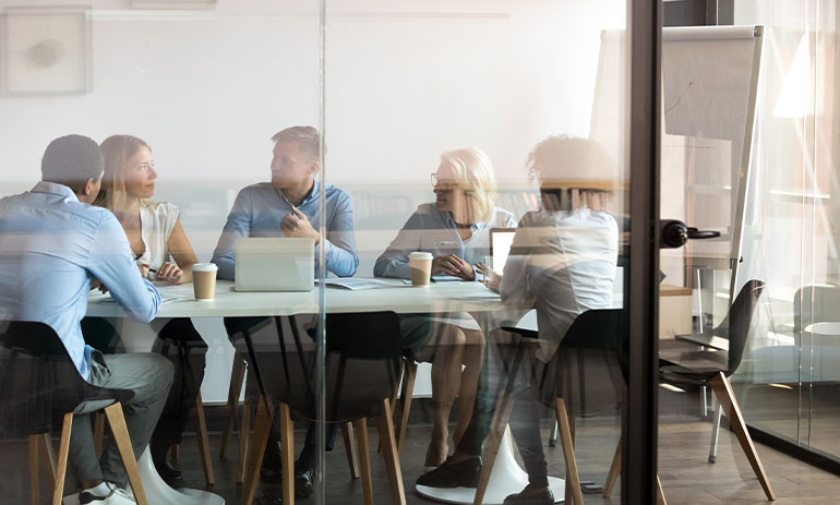 group of people sitting around a table talking