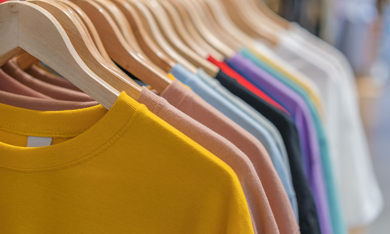 different coloured t-shirts on hangers
