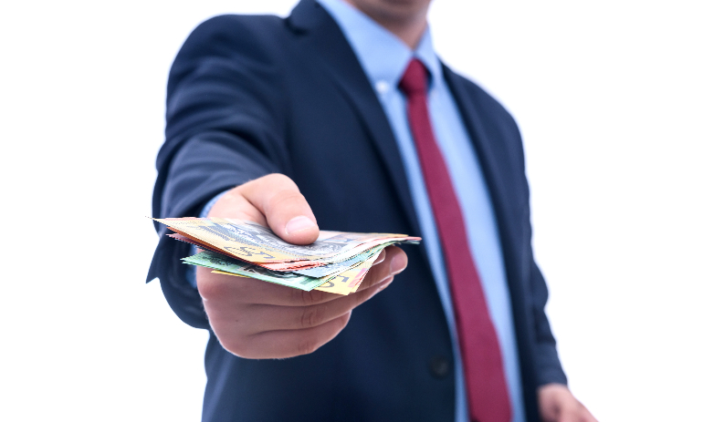 Man in suit offering Australian dollar banknotes isolated on white background