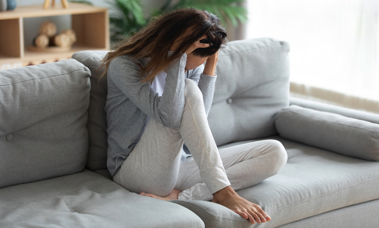 Stressed young person sitting on couch