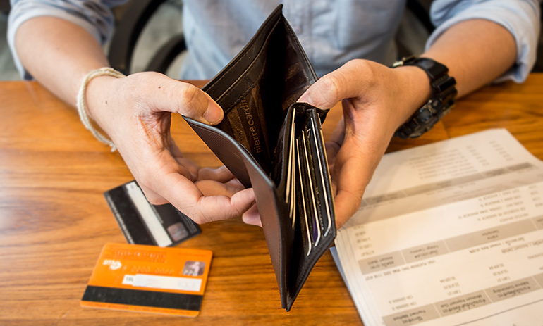 man looking into empty wallet