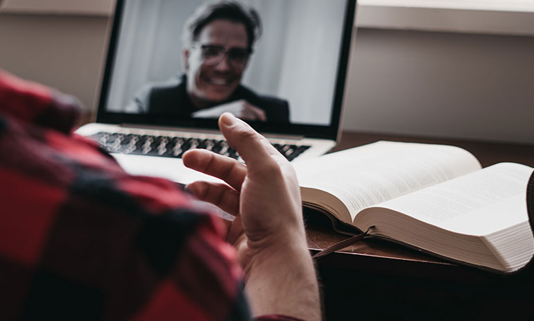 person sitting at a desk talking to someone on a video call