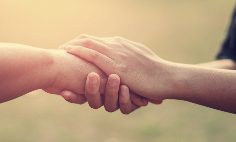 people old and young hand holding with sunset background