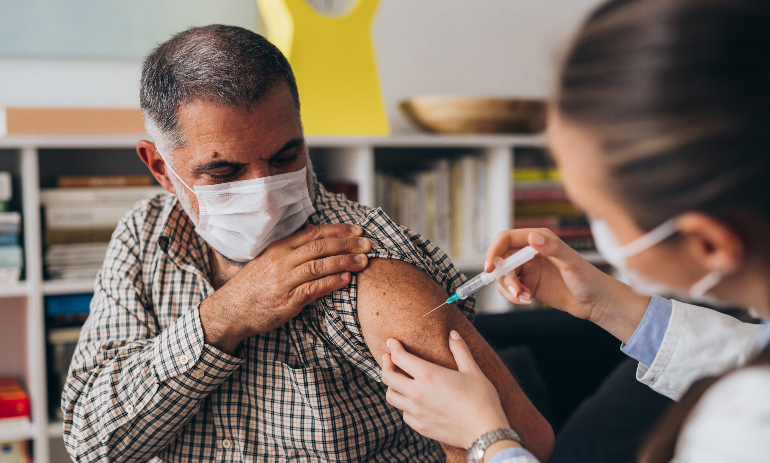 Person receiving injection while wearing face mask