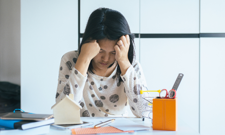 Woman looking stressed with head in hands