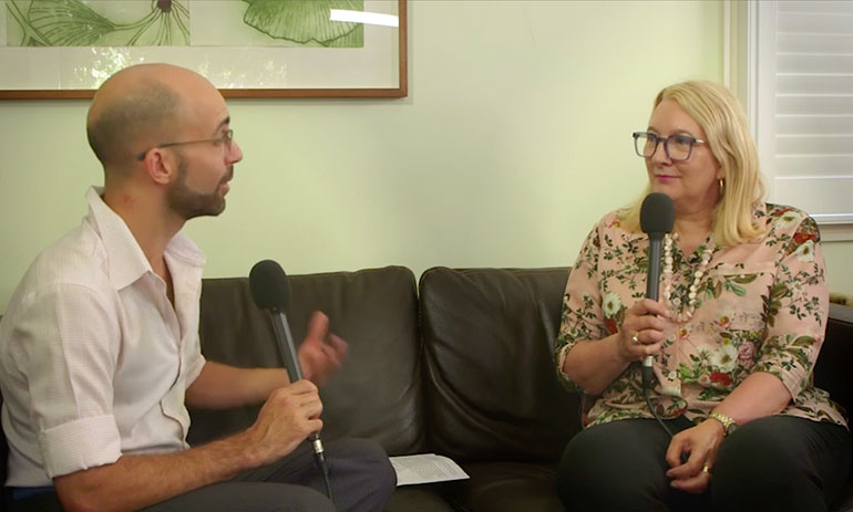 Philip Bateman talking to Catherine Brown, both sitting on a couch with microphones