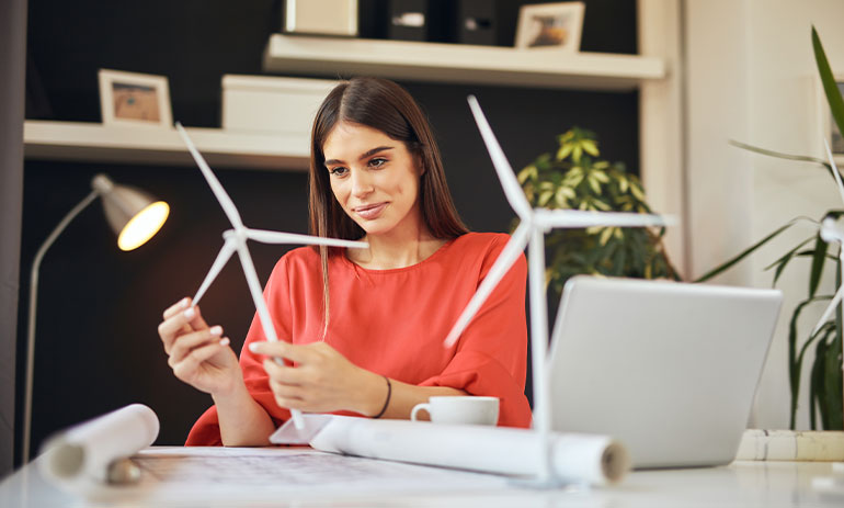 woman looking at model windmills at her desk