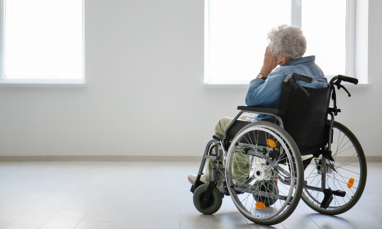 Lonely senior woman in wheelchair indoors