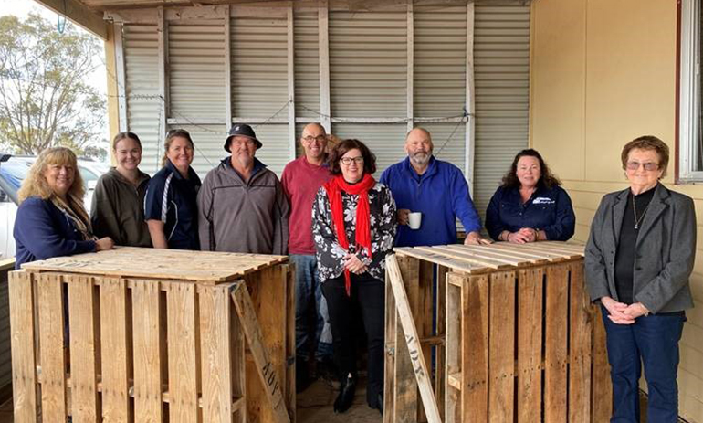 group of people standing next to crates