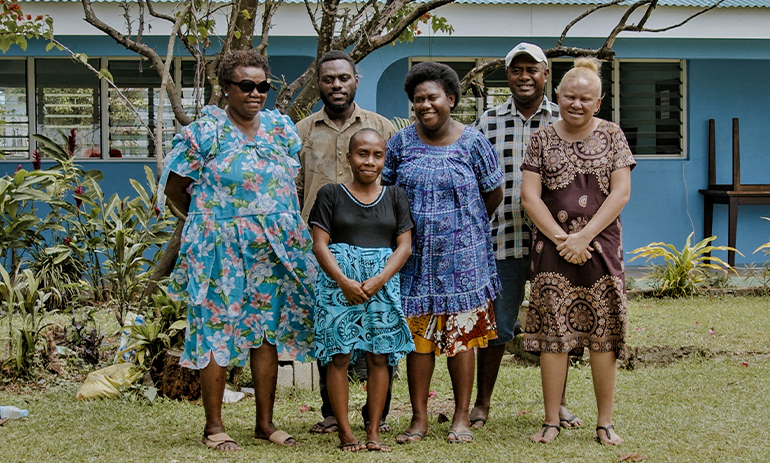 Group of people standing together outside.