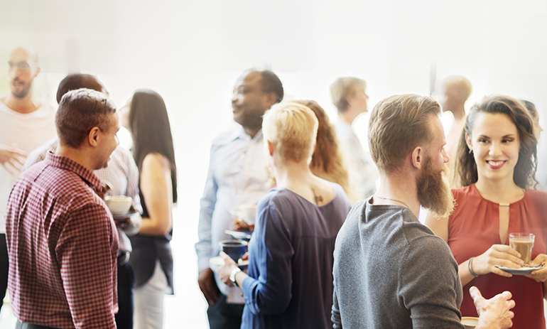 group of people standing around with drinks networking