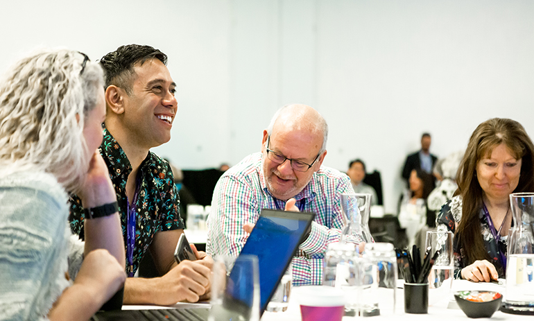 People sitting at a table at a conference