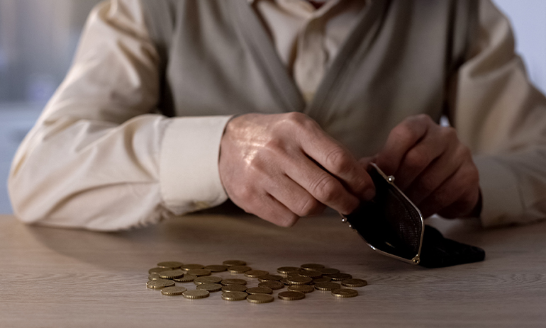 person emptying wallet on table counting coins