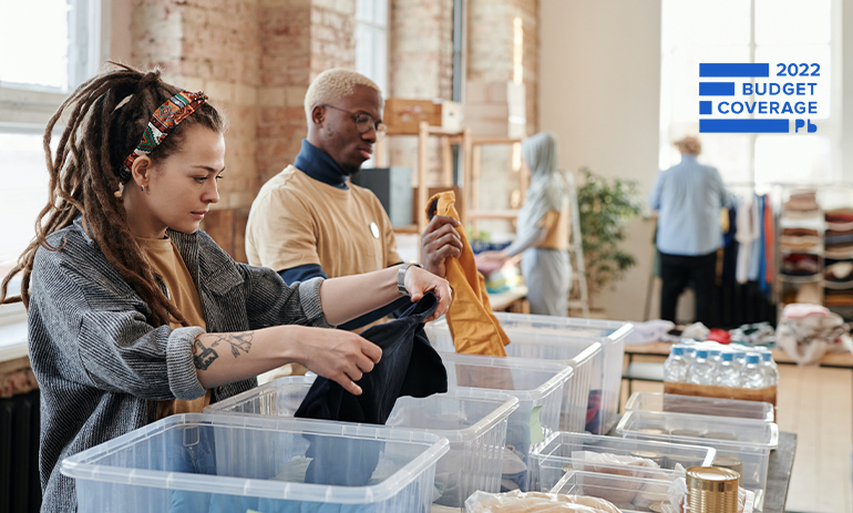 people folding clothing donations and putting them in boxes.