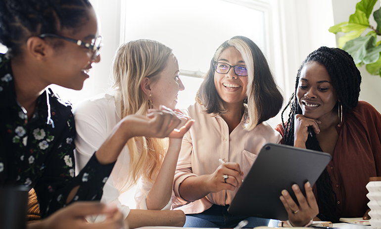 group of four diverse women sitting talking