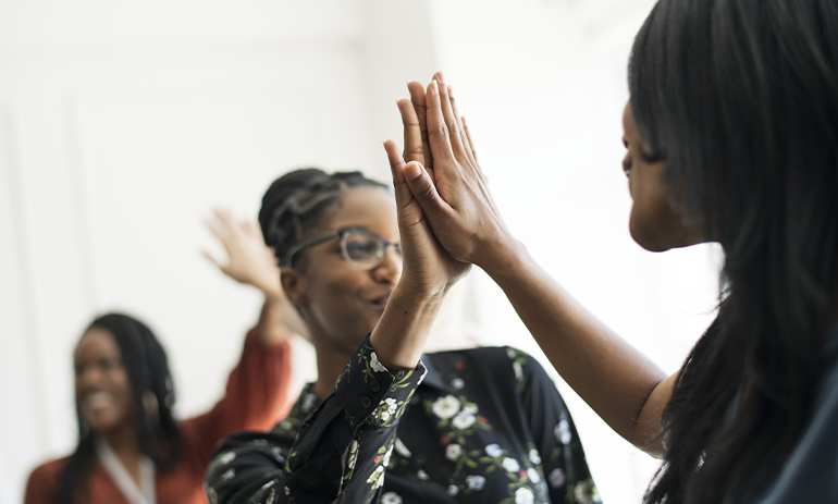 group of Black women high fiveing