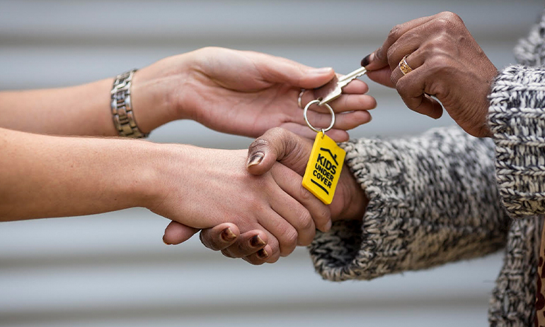 handing over keys with a Kids Under Cover keyring