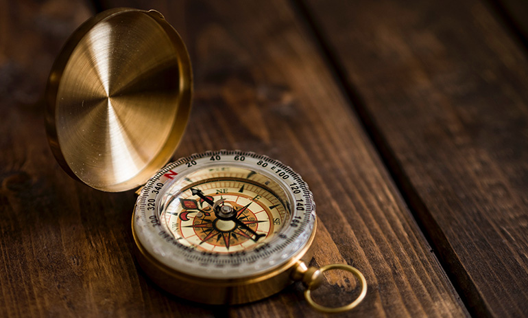 A compass on a wooden table