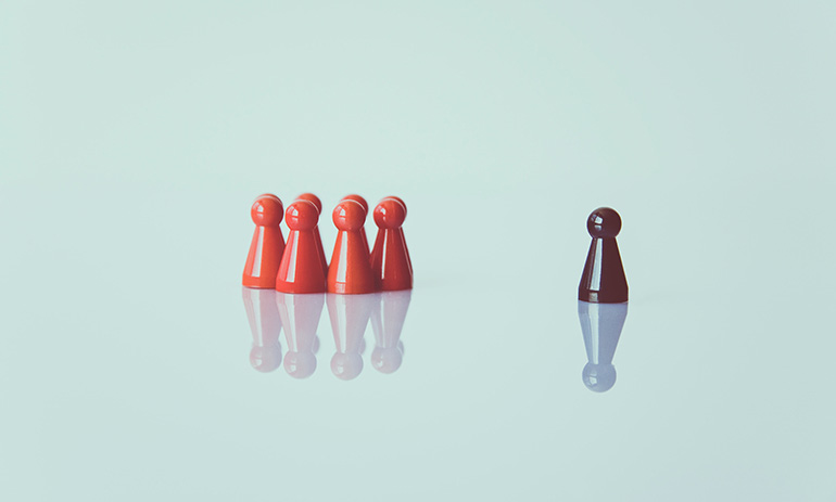 A group of red figurines sits behind a lone brown figurine out the front, looking like it leads the pack.